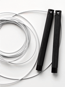 Sperax smart jump rope lying on gym floor with handles connected to fitness tracker app.